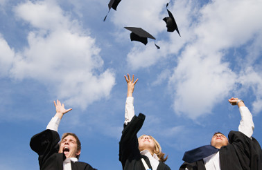 High school graduates throwing their mortarboards in the air --- Image by © Royalty-Free/Corbis