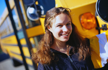 Student Standing by School Bus